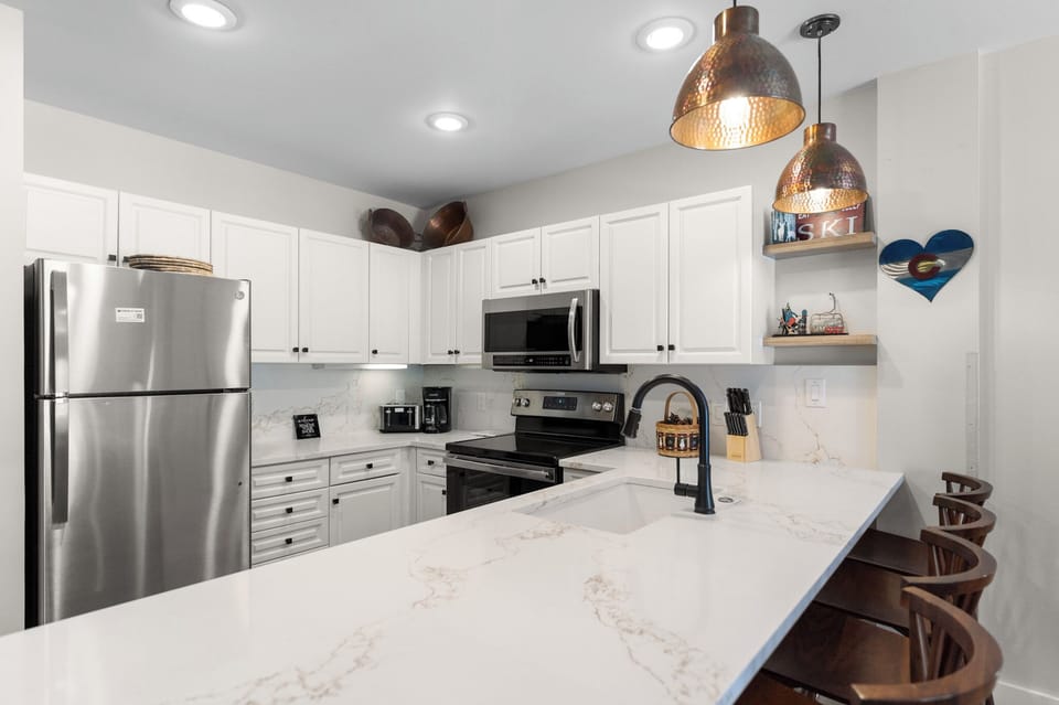 Your fully equipped kitchen awaits with marble countertops, stainless steel appliances, and stylish pendant lighting—perfect for preparing memorable meals during your stay.