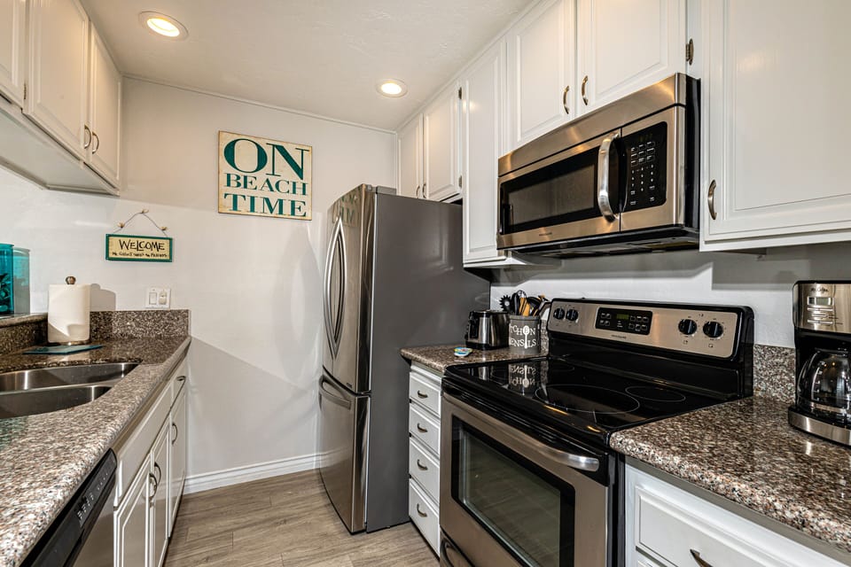 The chef's kitchen features stainless appliances, recessed lighting, a wood-look porcelain floor.
