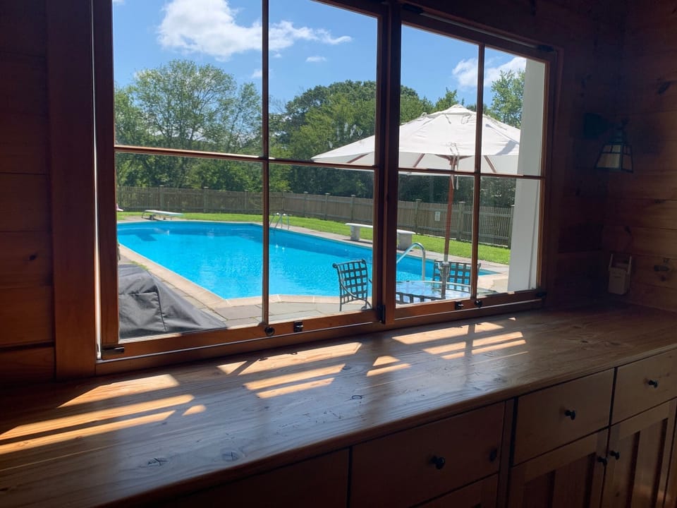 The windows swing in and hook to create a serving counter from the pool kitchen.