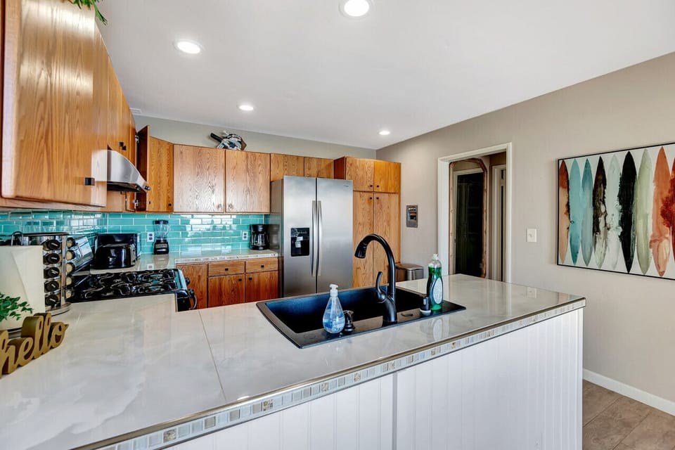 Bright kitchen w/ warm wood cabinetry & coastal-inspired accents.