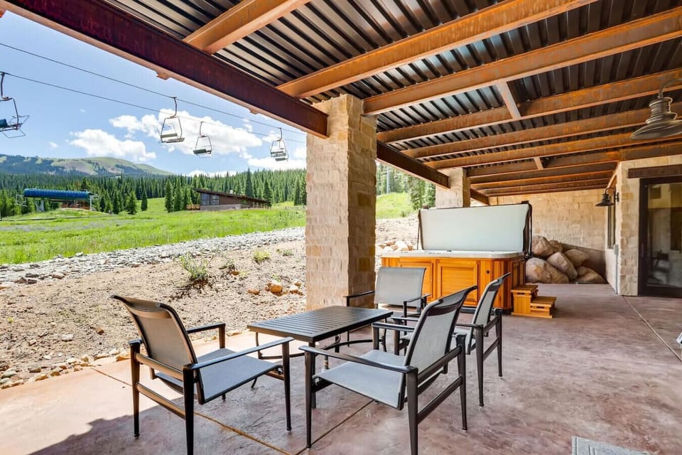 Enjoy morning coffee at the outdoor dining set under the cedar pergola, complete with a stainless-steel grill and sweeping meadow views.