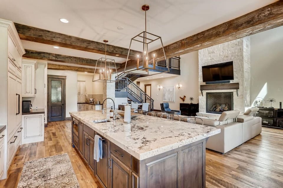 Prep gourmet meals on the massive granite island with built-in wine fridge, then cozy up by the stone fireplace—kitchen was a dream to cook in, one guest noted.