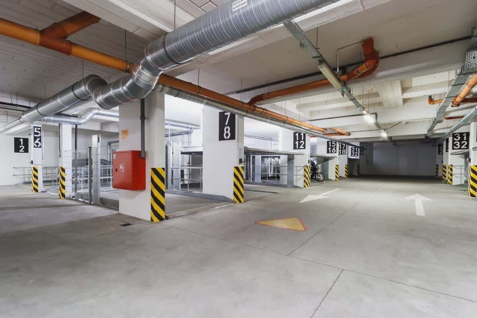 Another shot of the same parking area from a different angle, showcasing more parking spaces and pillars with yellow markings.