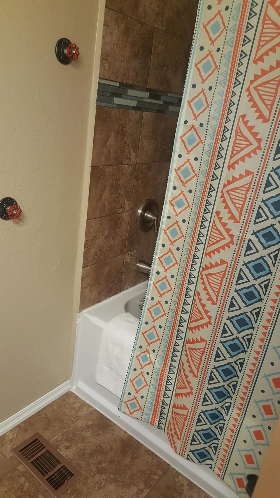 Shower and tub combo with faucet handles to hang your towel on.