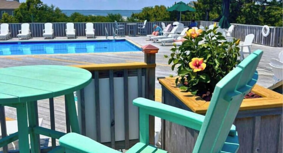 Relax by the sparkling community pool with your morning coffee, surrounded by vibrant flowers and stunning sea views—your perfect coastal retreat awaits.