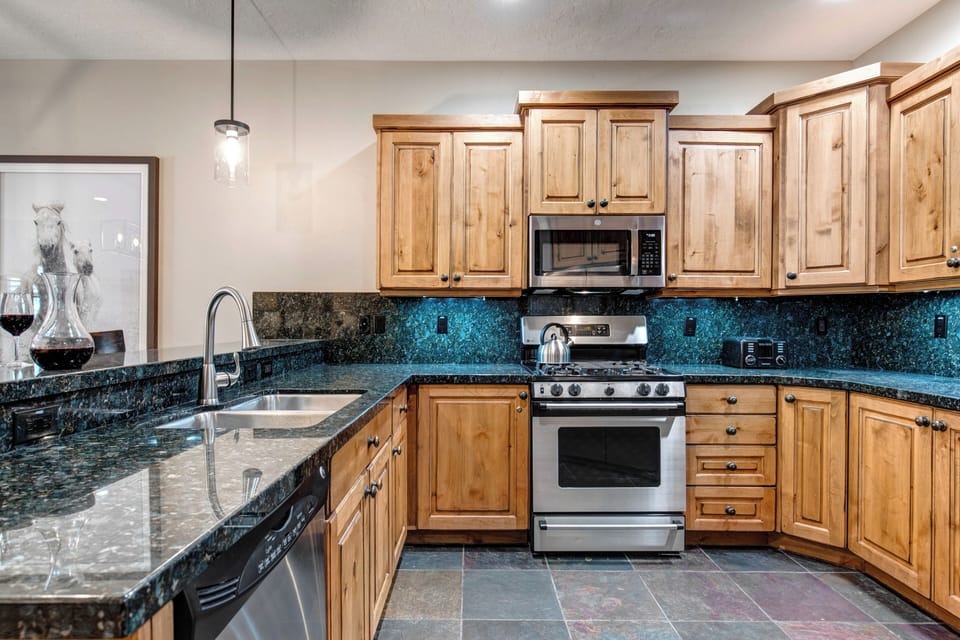 Your fully equipped kitchen features rich wood cabinetry, granite countertops, and modern stainless steel appliances to make meal preparation a joy.