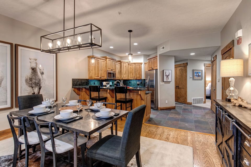 Your beautifully appointed open-concept living space features a modern kitchen with granite countertops, elegant dining area, and mountain-inspired décor perfect for memorable meals together.