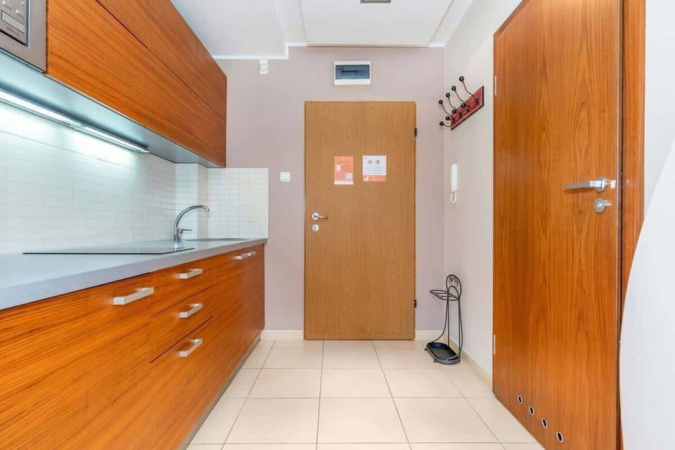 Kitchenette with an induction hob, refrigerator with freezer and microwave/entrance to the apartment.