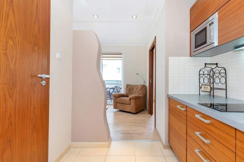 Kitchenette with an induction hob, refrigerator with freezer and microwave.