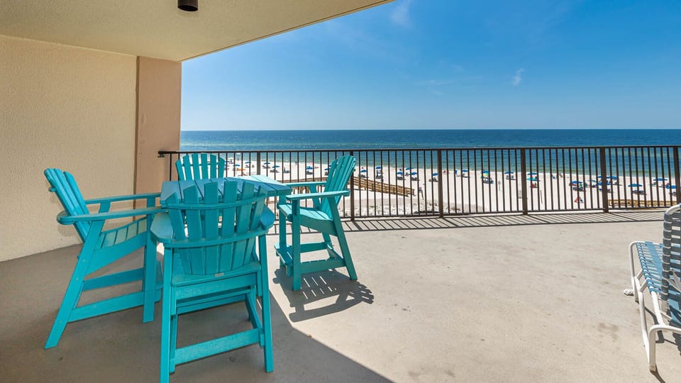 Relax on the turquoise chairs of this balcony while enjoying the breathtaking beach view and gentle sea breeze