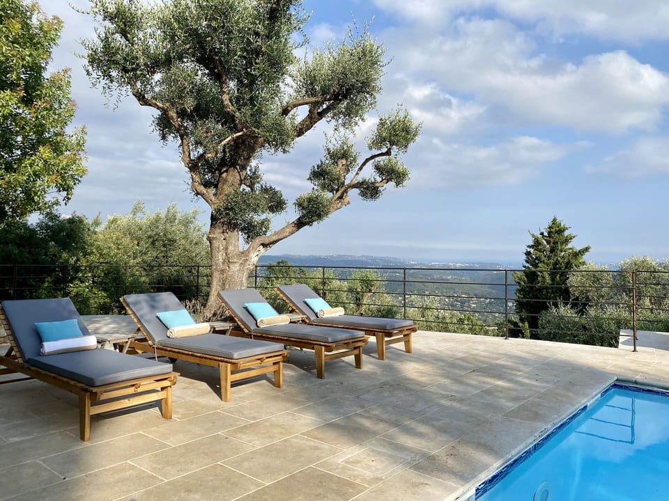 Large south facing pool with sun loungers, sofas and boule area.