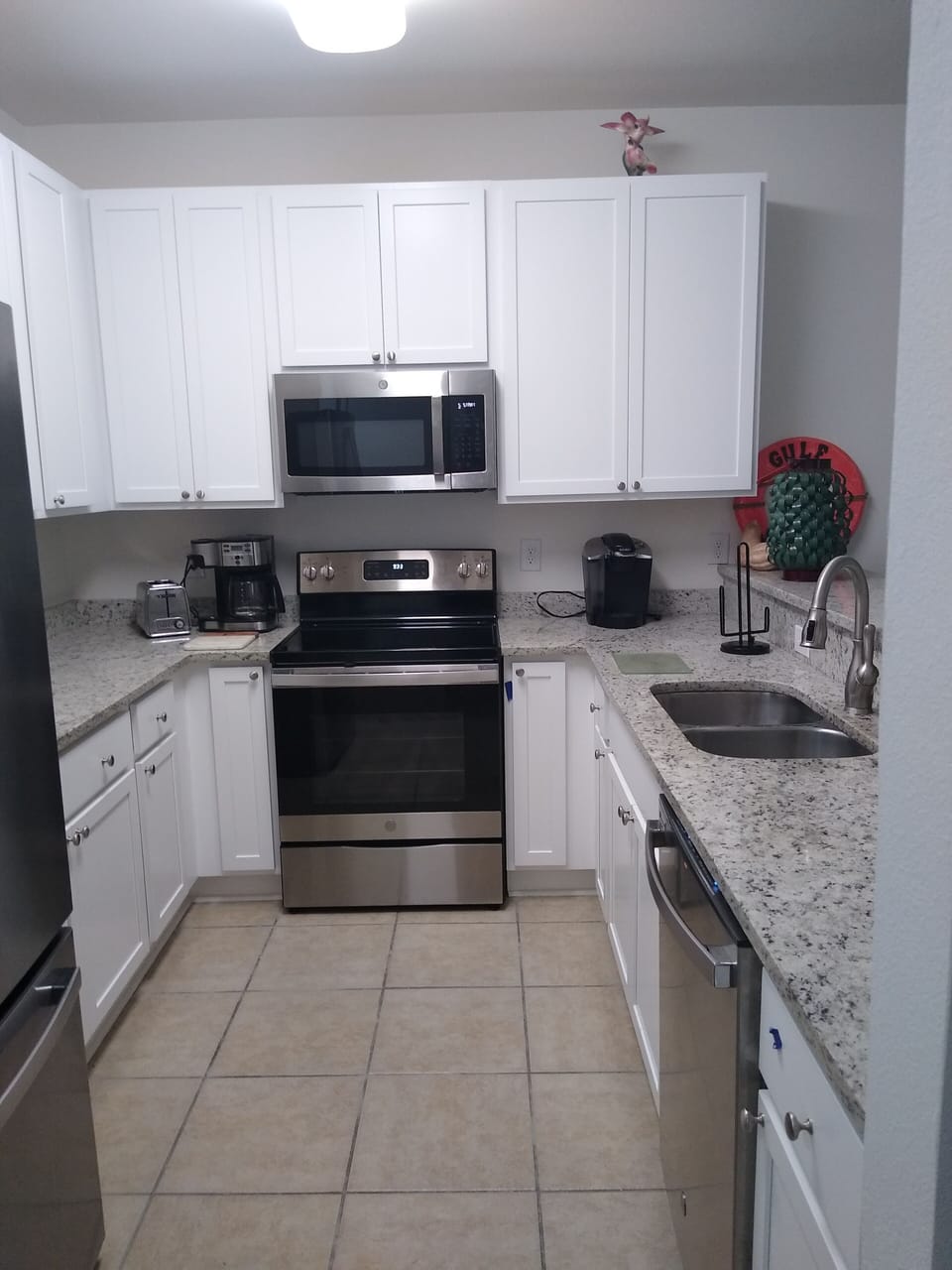 Kitchen with Granite Countertops, Stove, Refrigerator, Microwave on a Tile Floor