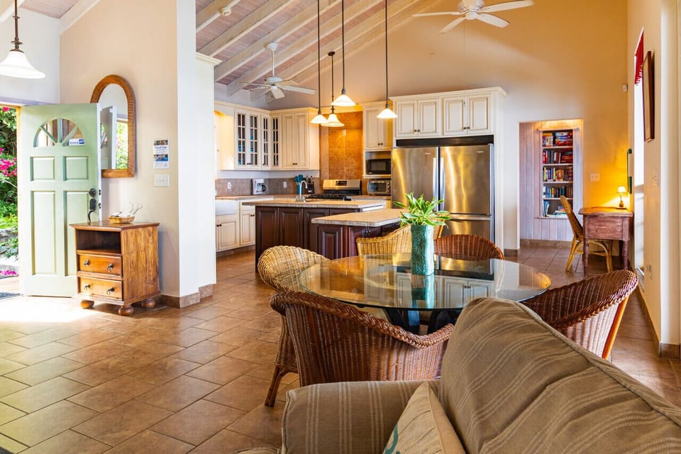 Living room is between the back deck, the entrance, and the kitchen.