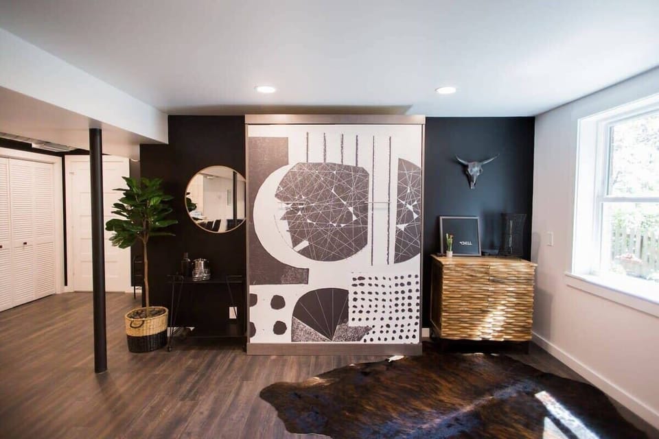 Upon entrance, this area is directly to your right: A "foyer" with a bar cart, wall mural, and cabinet to the right which serves as our "welcome desk" and also has stored linens for the Murphy bed hidden behind the mural.