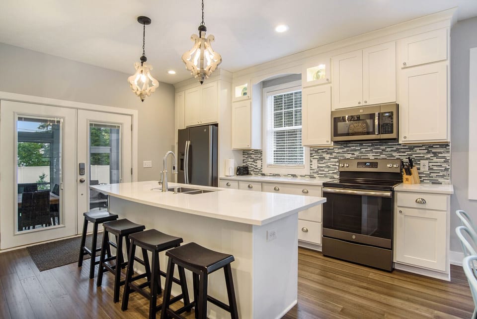 Well stocked kitchen with island seating and quartz countertops. 