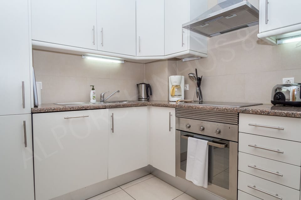 Fully equipped kitchen in Alporchinhos 840 holiday apartment with modern appliances, granite countertops, and under-cabinet lighting ideal for self-catering holidays in the Algarve