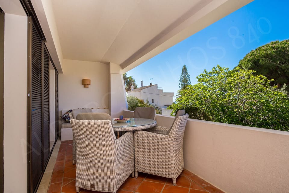 Private balcony at Alporchinhos 840 holiday apartment with comfortable wicker seating and lush garden views, perfect for alfresco dining and relaxation in the Algarve sunshine