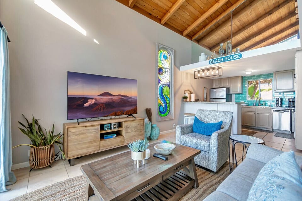 Rustic wood-beamed living room w/ cozy seating & open flow to the kitchen.