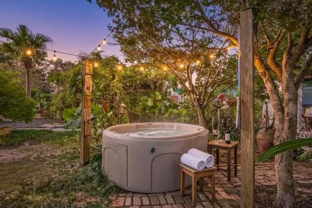 Hot tub under string lights and tropical canopy offers couples or solor travelers a serene escape minutes from downtown Pensacola restaurants and beaches