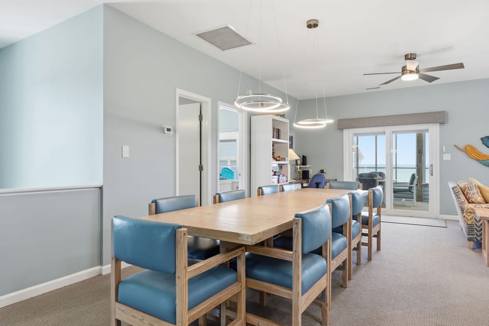 Gather around this spacious dining table with seating for eight, where you'll enjoy meals together while taking in serene ocean views through the patio doors.