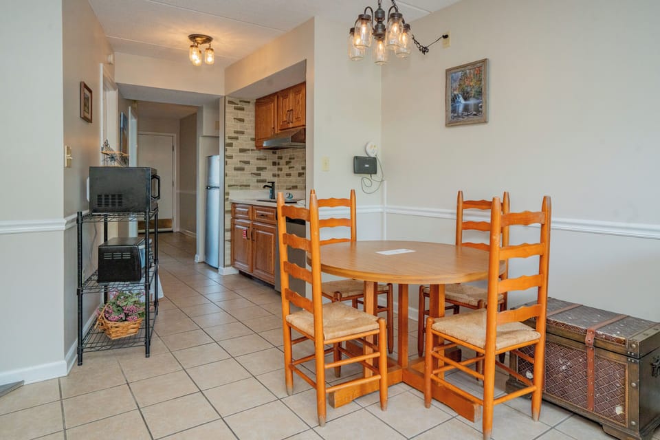 Gather around this inviting dining table in your fully equipped kitchen, where warm wood tones and charming details create the perfect spot for sharing meals together.
