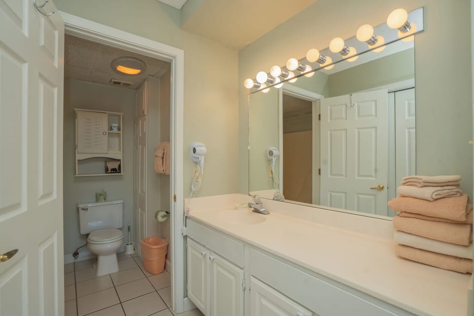 Step into your bright, serene bathroom where soft lighting and fresh towels welcome you. The spacious vanity gives you plenty of room to unwind and prepare for your day in comfort.