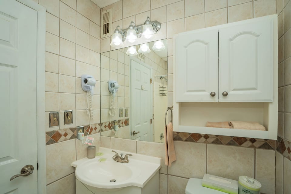 Step into your bright, spotlessly clean bathroom with plenty of storage for all your essentials. The vanity offers ample space to spread out, while fresh towels await your arrival.