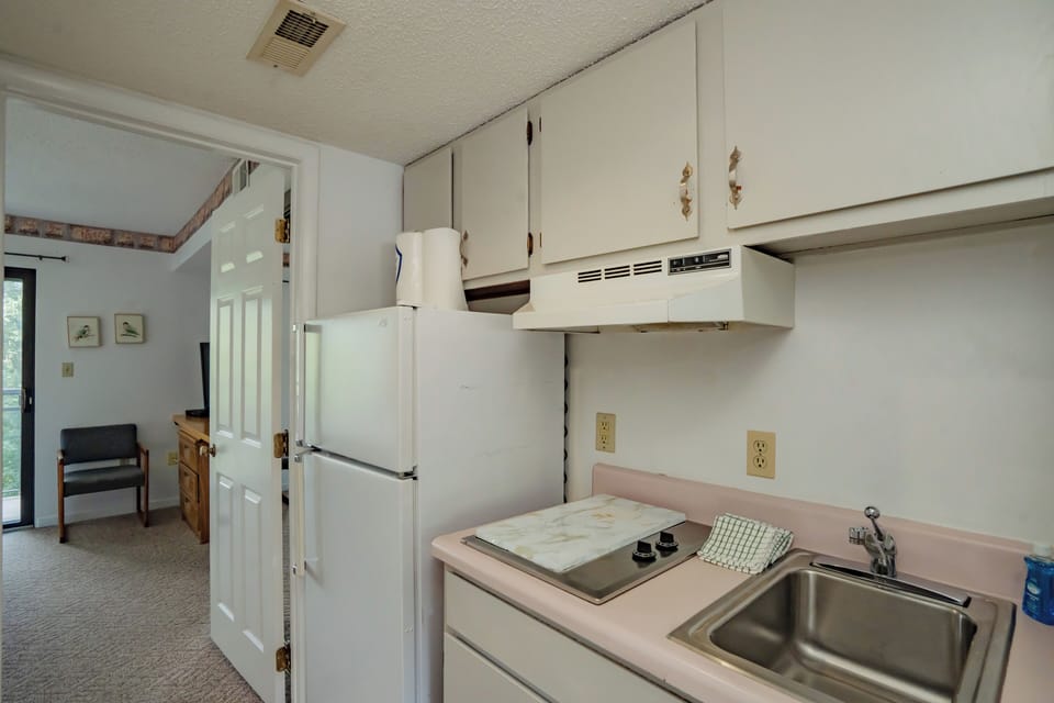 Your kitchen is fully equipped with everything you need for meal prep, featuring a stove, refrigerator, and ample counter space for easy cooking during your stay.