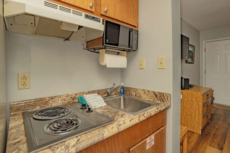 Your compact kitchenette has everything you need: a microwave, stove, and sink with granite countertops, plus handy under-cabinet storage for easy meal prep.