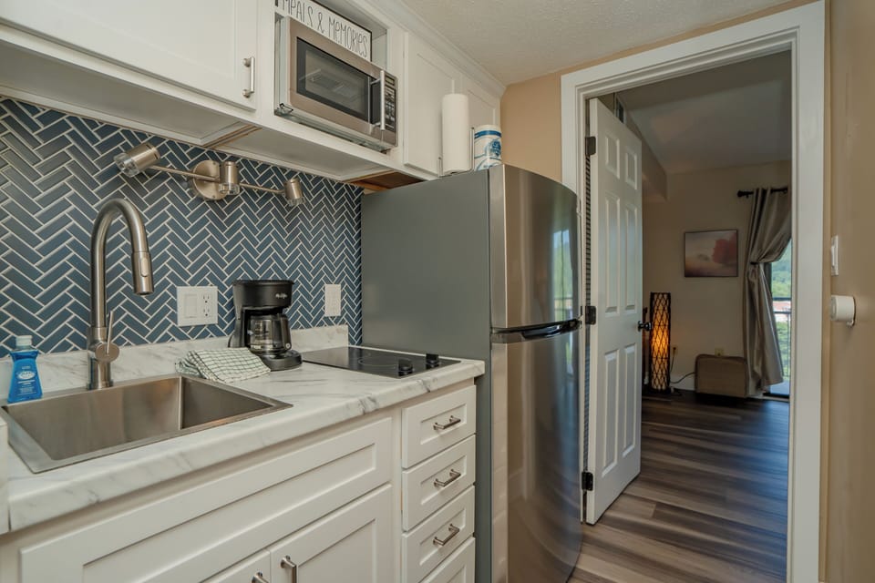 Step into your fully equipped kitchen with modern stainless-steel appliances, marble-style countertops, and a striking herringbone tile backsplash. Everything you need to prepare your favorite meals awaits.