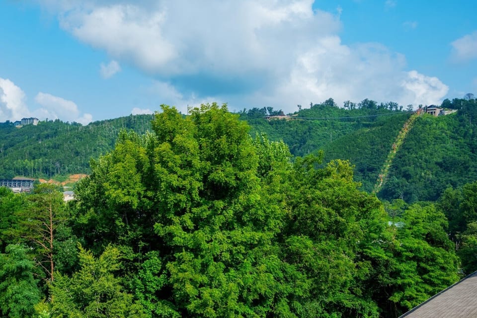 Verdant hillsides and blue skies surround the property, offering a tranquil mountain retreat setting in the heart of nature.