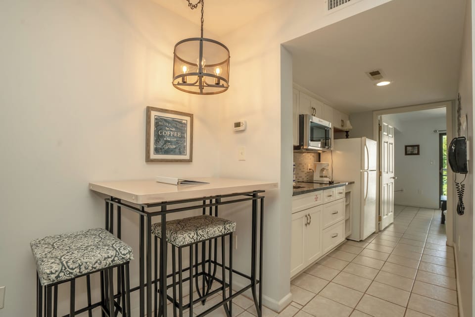 Bright, open-concept space perfect for your morning coffee and meal prep, with a cozy breakfast bar and a fully equipped kitchen just steps away.
