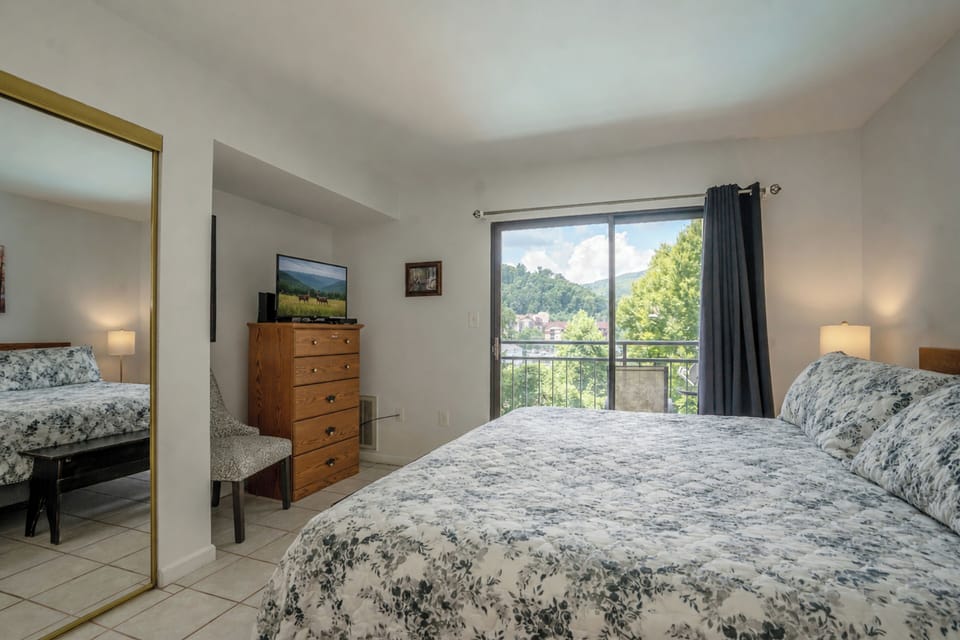 Your peaceful retreat features a plush queen bed dressed in soft linens and opens to a private balcony where mountain and lush greenery views await. Natural light floods the space, making it feel bright and airy.