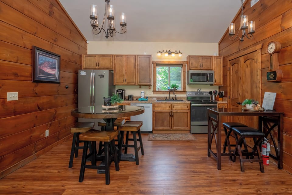 Step into your cozy cabin-style kitchen, where warm wood walls and natural light invite you to brew morning coffee and gather around the rustic table for meals with loved ones.