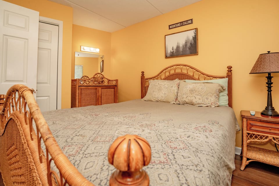 Drift off in this warm, inviting bedroom with its charming wicker furnishings and soft linens. Your cozy retreat awaits after a day of mountain adventures.