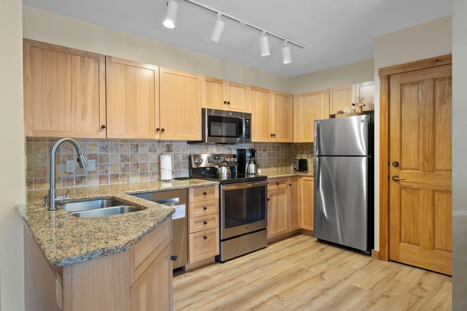 Full kitchen featuring granite countertops and stainless steel appliances.