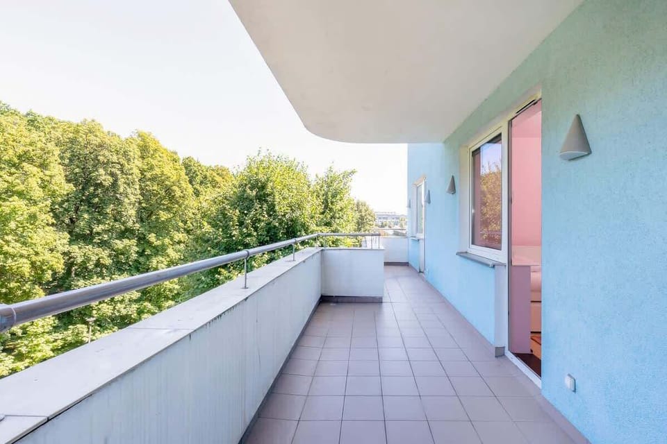 Spacious balcony with outdoor furniture. 