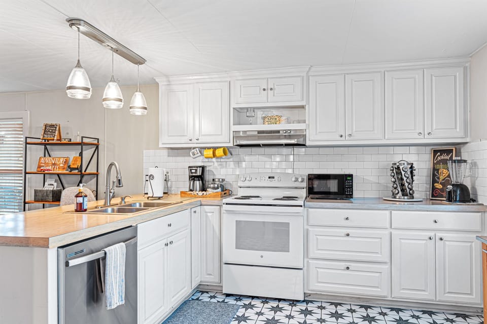 Kitchen is fully stocked with pots, pans, utensils, blender, toaster, microwave, spices, Alexa for music, and two bar stools.