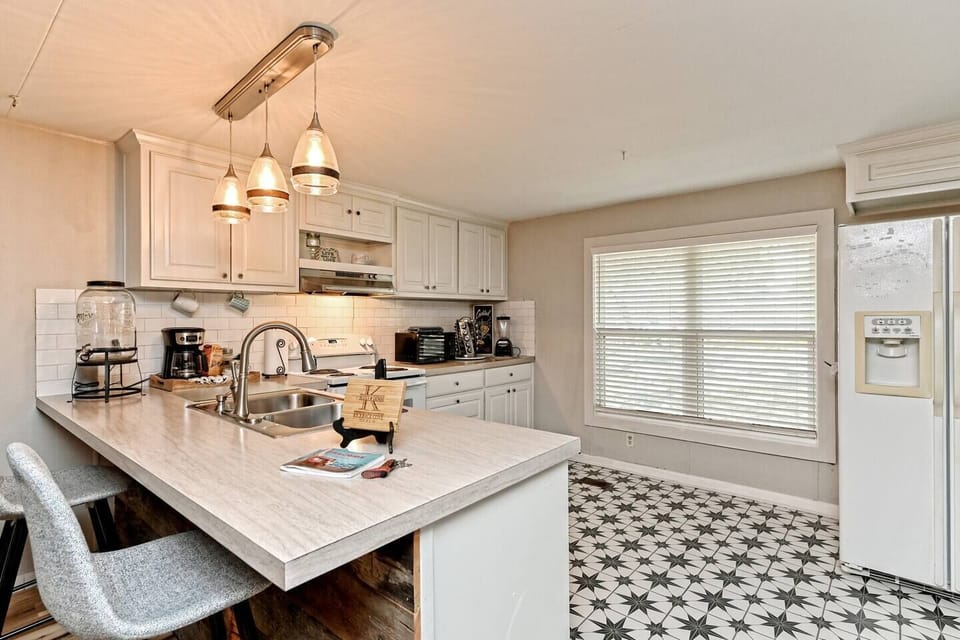 Kitchen is fully stocked with pots, pans, utensils, blender, toaster, microwave, spices, Alexa for music, and two bar stools.