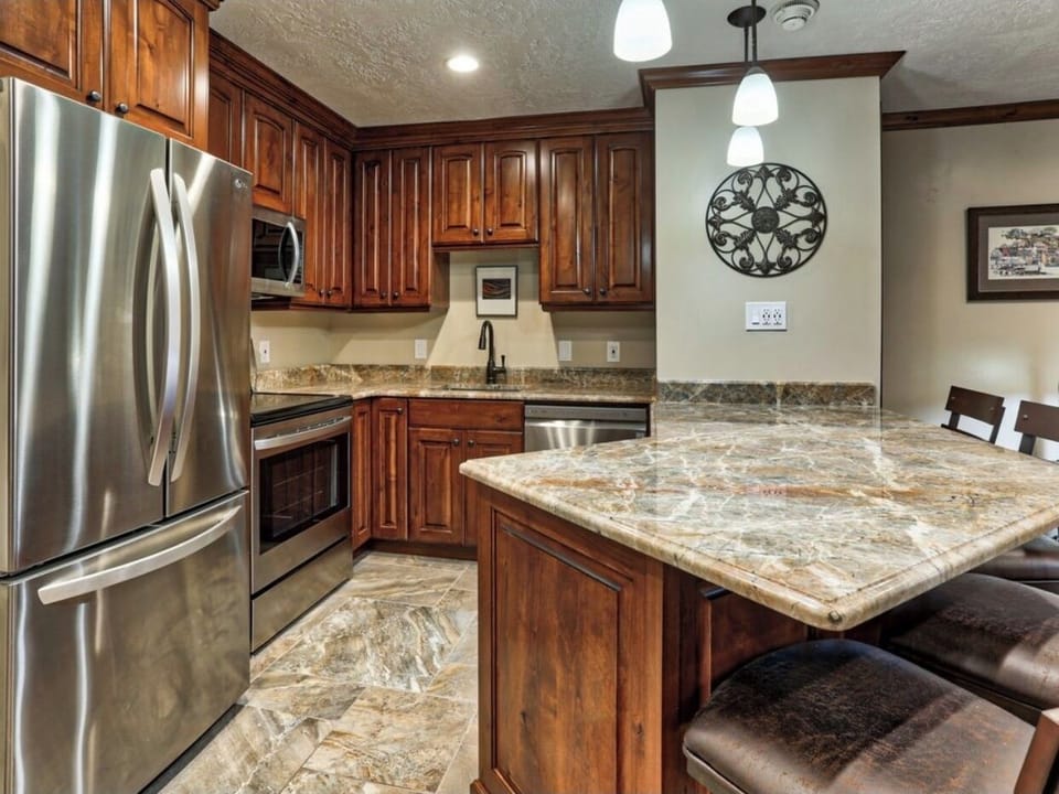 Kitchen: custom countertops, cabinetry, & full-size stainless steel appliances.