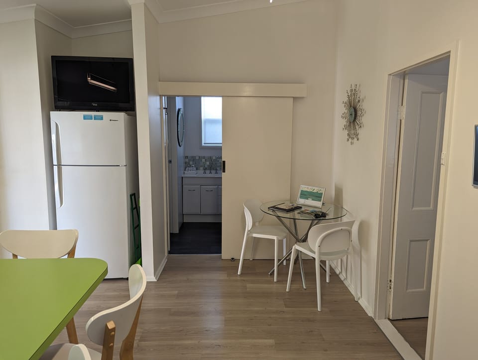Kitchen eating nook, TV, fridge and information book with all you need to know.