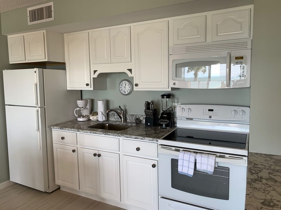 Kitchen has everything you need including dishes, glasses and pots and pans