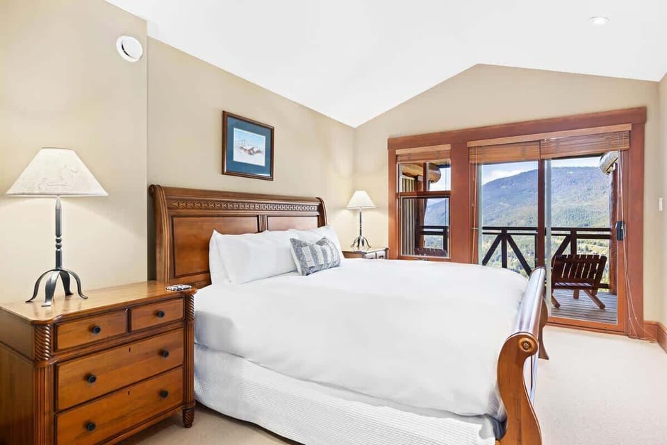 - Bedroom 1 – bright king room with balcony access and relaxing mountain views 
- Warm wood accents and soft bedding create a peaceful inviting atmosphere 
- Perfect restful space for unwinding after exploring the outdoors  
