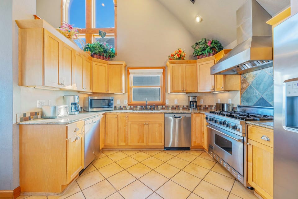 Your fully-equipped kitchen features warm wood cabinetry, stainless steel appliances, and ample counter space for preparing memorable meals together.