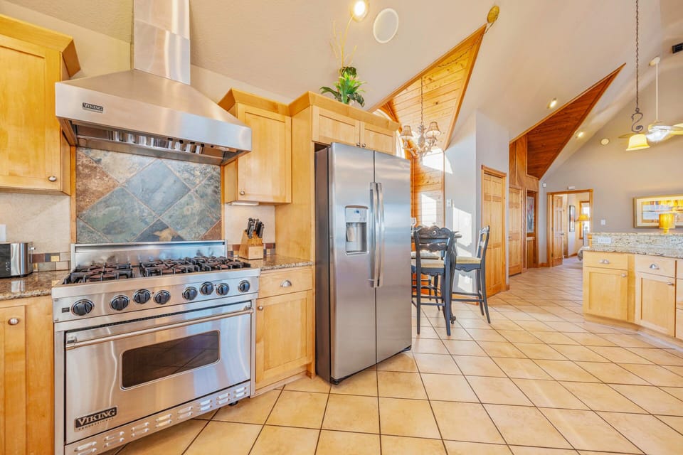 Your gourmet kitchen awaits with professional Viking range, spacious granite counters, and soaring vaulted ceilings for memorable meal preparation.
