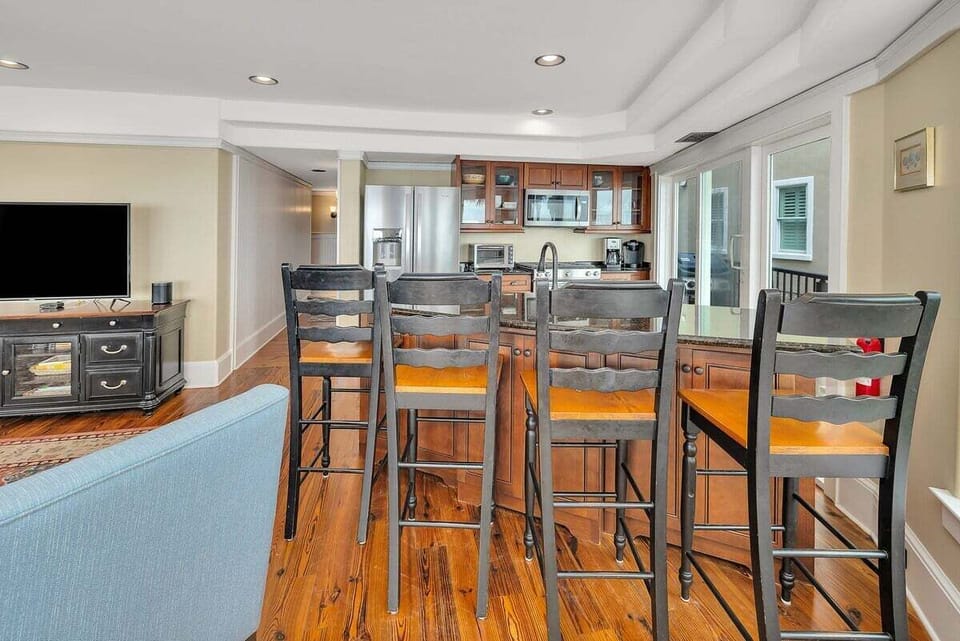 Kitchen with bar stools, stainless appliances, and hardwood floors