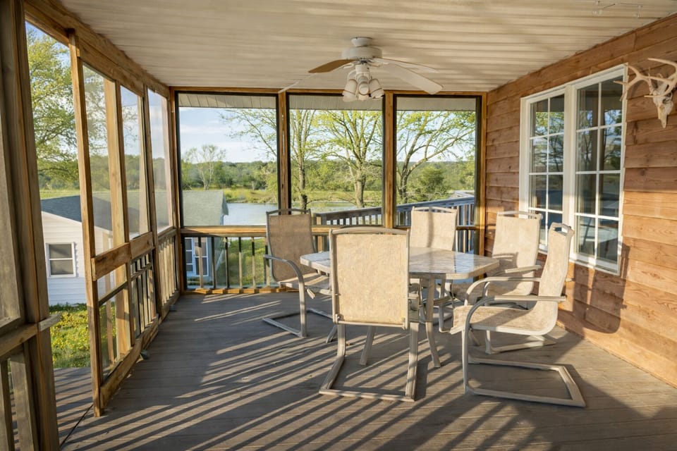 Spacious screened-in deck with outdoor dining at Pond View Loft. Gather around the table to enjoy fresh air, country views, and peaceful mornings or evenings — all protected from the elements for year-round comfort.