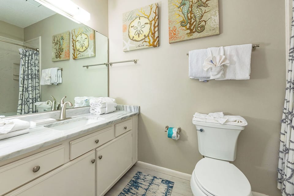 Soft artwork adds a coastal touch to the guest bath where you refresh and unwind after a fun day