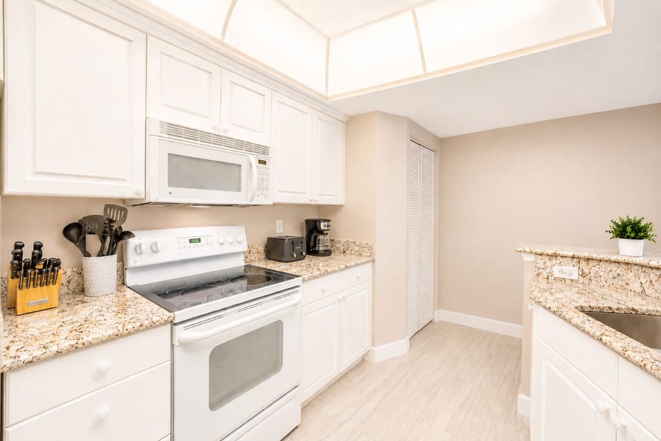 Bright, spacious kitchen with modern appliances and granite countertops lets you easily whip up meals during your stay, with everything you need at your fingertips.