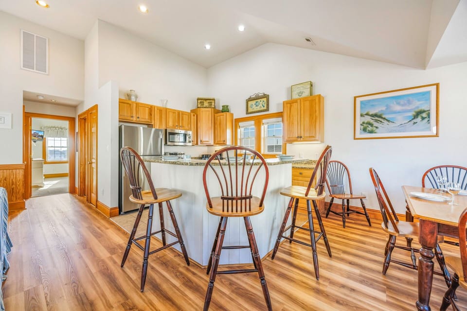 Your spacious kitchen features warm wood cabinets, stainless steel appliances, and a welcoming breakfast bar perfect for morning coffee or casual dining.